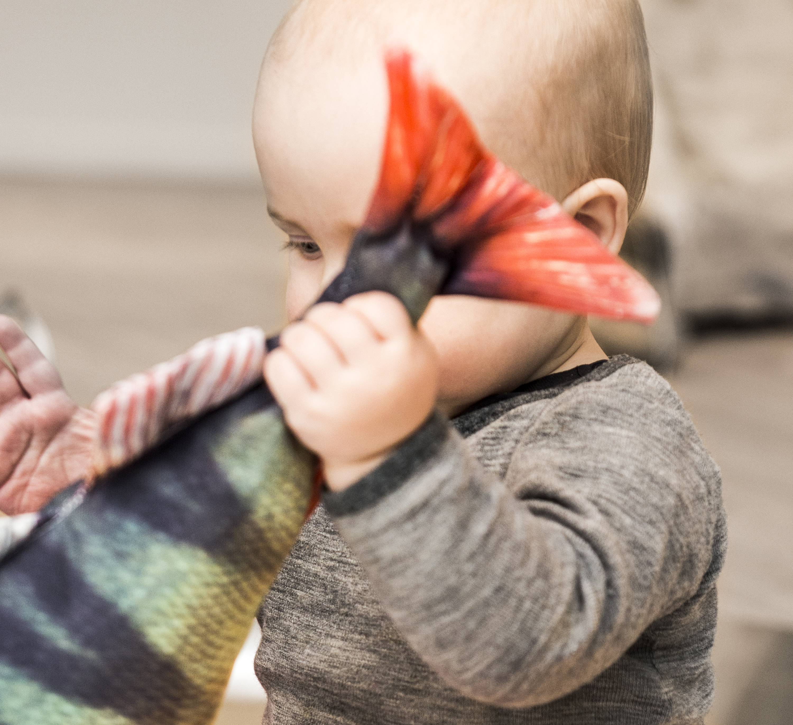'Bäbis som håller i stjärtfenan på en fisk av tyg.'