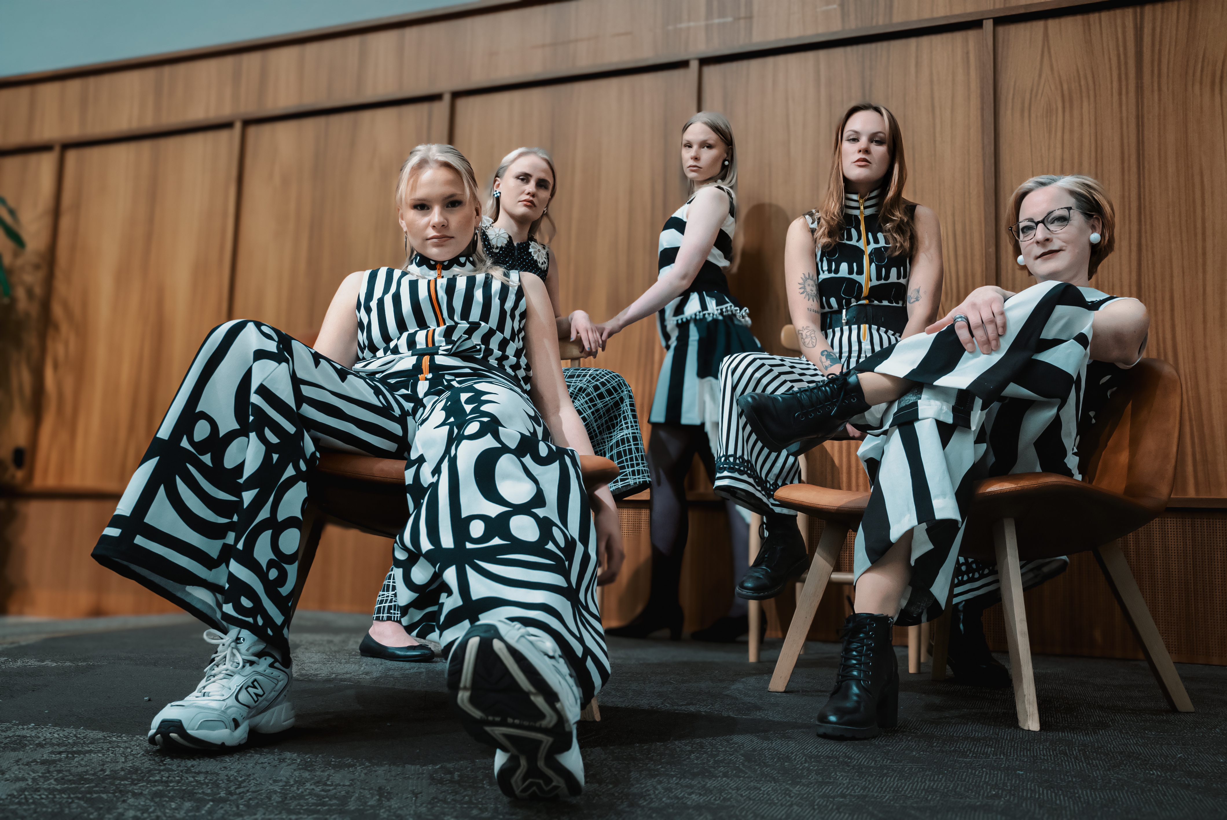 Fem tjejer som poserar med svartvita modekläder.