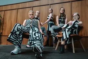 Fem tjejer som poserar med svartvita modekläder.