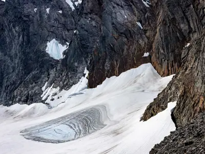 'Smältande glaciär vid en brant bergsvägg.'