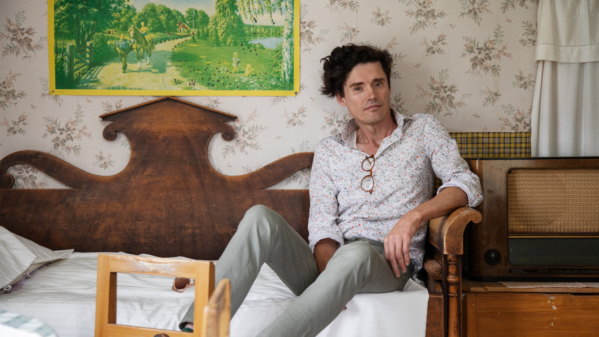 Gustav Bergström sitting on an old-fashioned sofa.